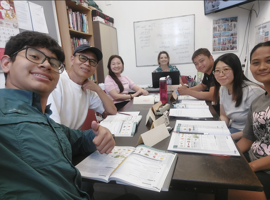 Diverse students in classroom with teacher.