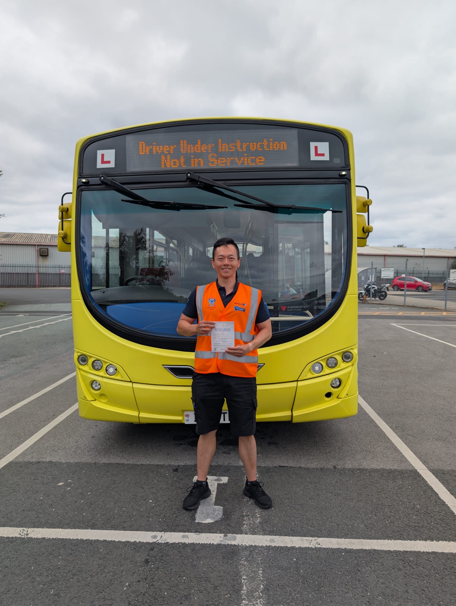 New bus driver with his pass certificate in front of a Warrington's Own bus.